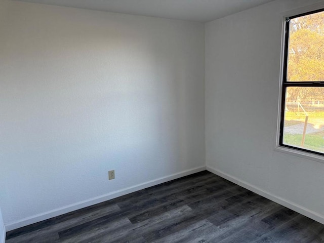 spare room with a healthy amount of sunlight and dark hardwood / wood-style flooring