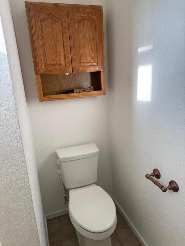 bathroom featuring toilet and tile patterned flooring