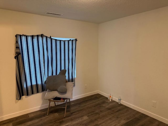 unfurnished room featuring dark hardwood / wood-style floors and a textured ceiling