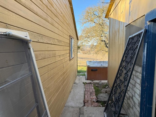 view of home's exterior with a hot tub