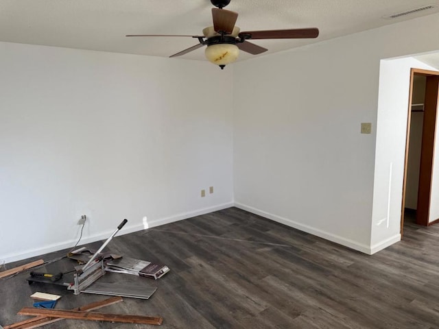 spare room featuring dark wood-type flooring and ceiling fan