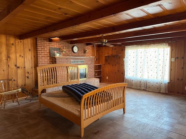 bedroom featuring wood ceiling, beam ceiling, a brick fireplace, and wood walls