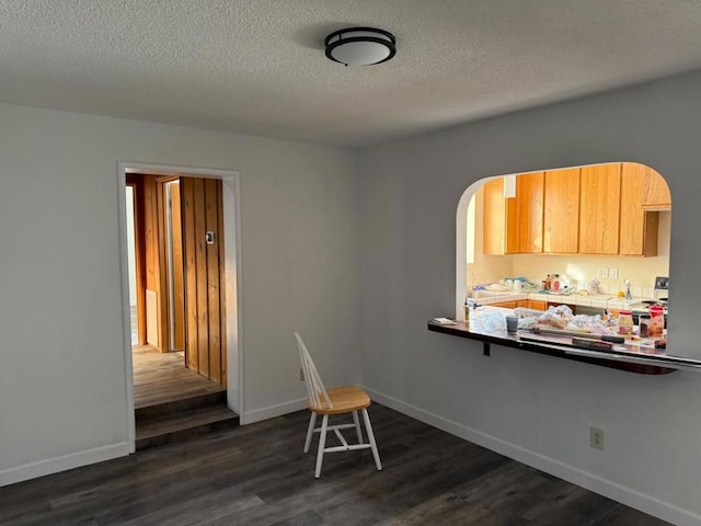 dining area with dark hardwood / wood-style floors and a textured ceiling