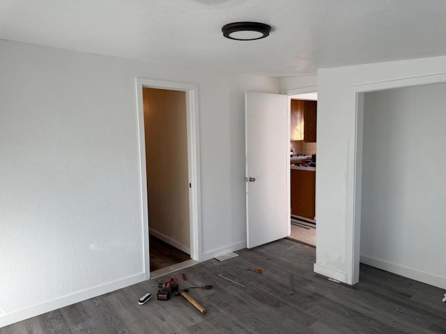 unfurnished bedroom with dark wood-type flooring