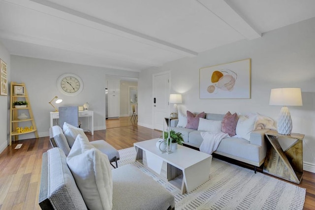 living room with beamed ceiling and light hardwood / wood-style floors