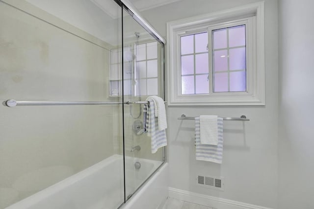 bathroom featuring bath / shower combo with glass door