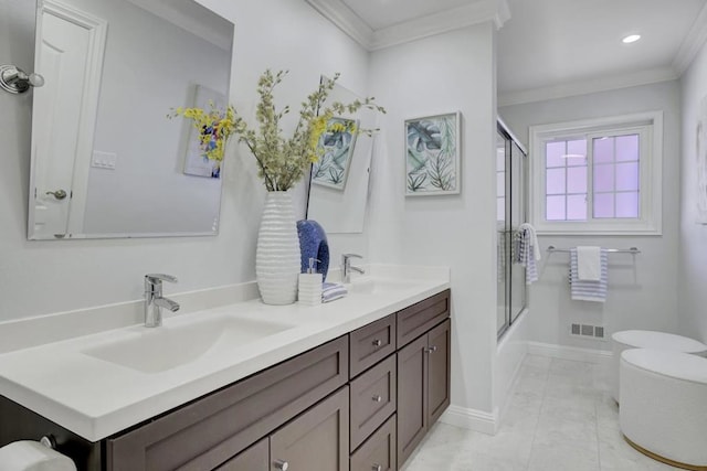 bathroom featuring ornamental molding, vanity, and bath / shower combo with glass door