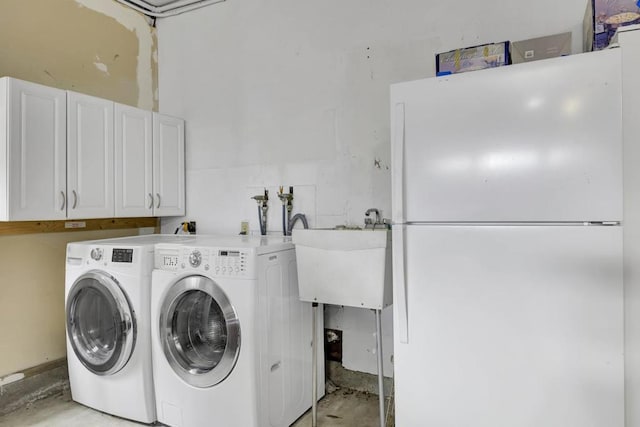 clothes washing area with washer and dryer, sink, and cabinets