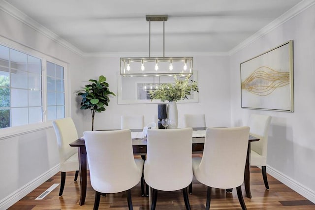 dining space with wood-type flooring and ornamental molding