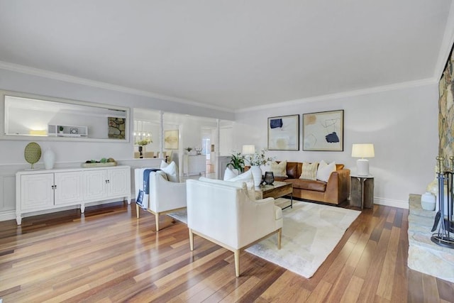 living room featuring ornamental molding, a notable chandelier, and light hardwood / wood-style floors