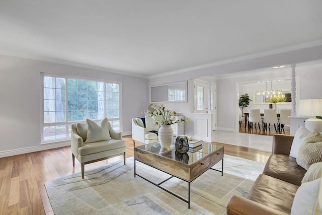 living room with crown molding, light hardwood / wood-style floors, and a notable chandelier