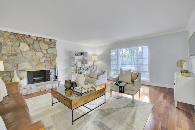 living room featuring hardwood / wood-style flooring, ornamental molding, and a fireplace