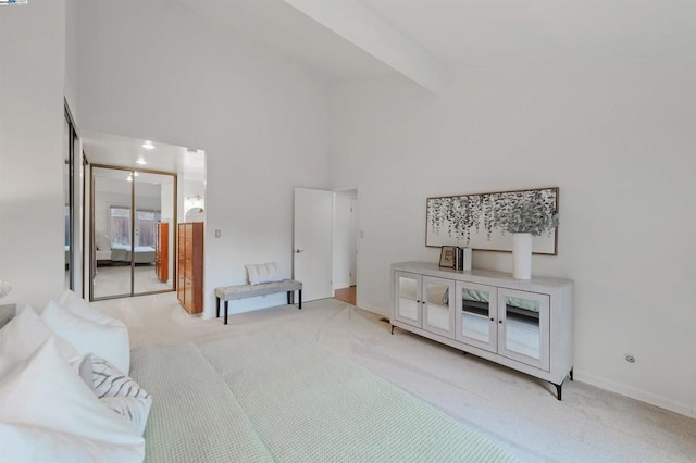 bedroom with beam ceiling, light carpet, high vaulted ceiling, and a closet