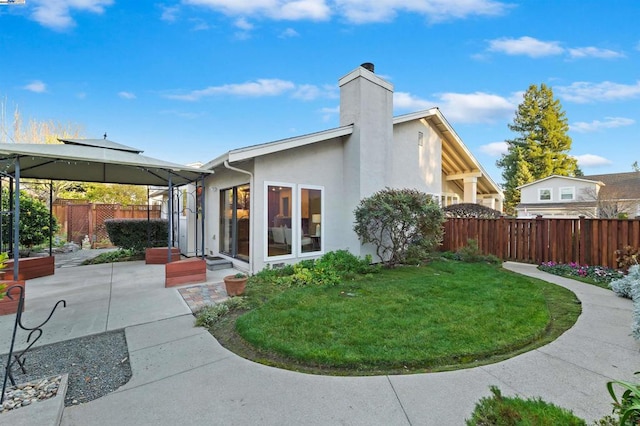 back of house featuring a yard, a gazebo, and a patio