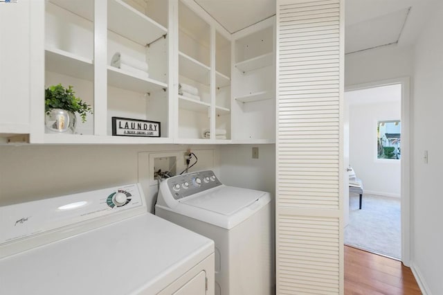 washroom with wood-type flooring and washer and dryer