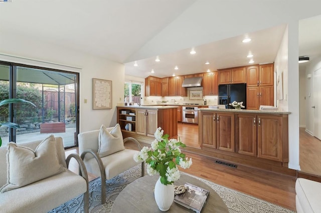 living room featuring high vaulted ceiling and light hardwood / wood-style floors