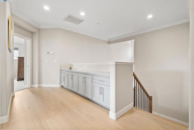 interior space featuring ornamental molding and light hardwood / wood-style floors