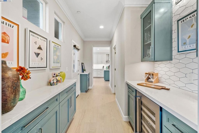 corridor featuring ornamental molding, beverage cooler, and light hardwood / wood-style floors