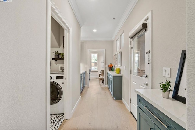 laundry area featuring ornamental molding, washer / dryer, and light wood-type flooring