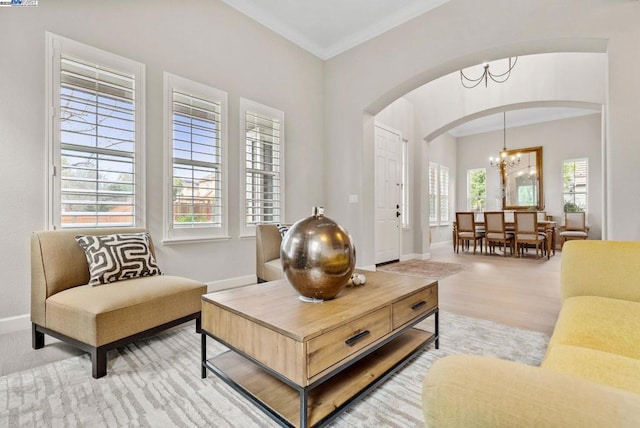 sitting room with ornamental molding, light hardwood / wood-style floors, and a notable chandelier