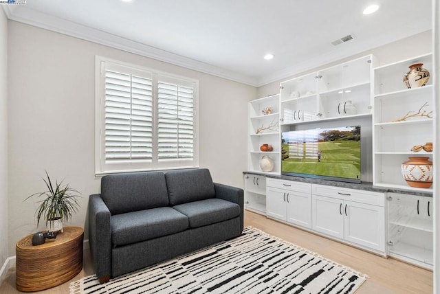 living room with ornamental molding and light hardwood / wood-style floors