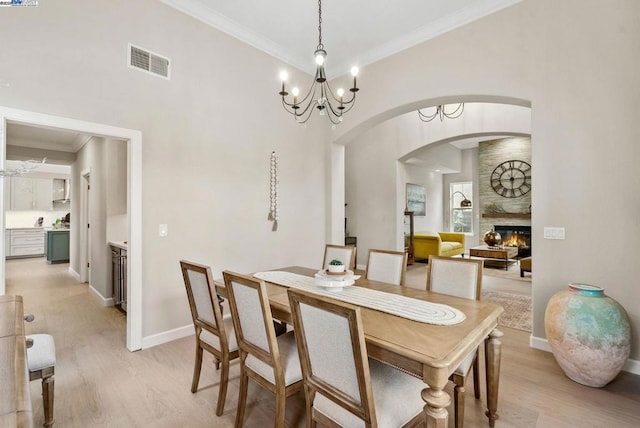 dining room featuring a notable chandelier, ornamental molding, and light wood-type flooring