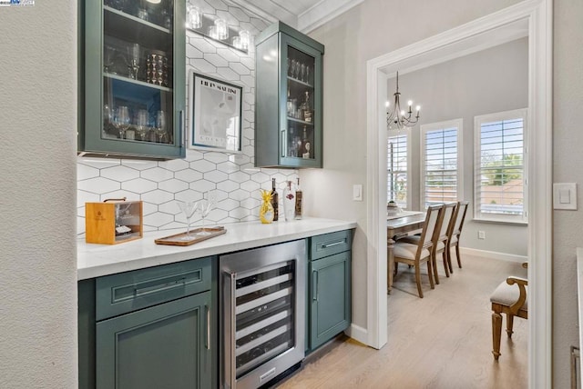 bar featuring pendant lighting, wine cooler, decorative backsplash, light hardwood / wood-style floors, and crown molding