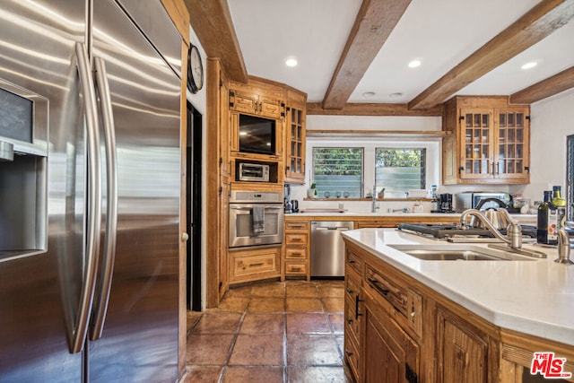 kitchen with sink, beam ceiling, and stainless steel appliances