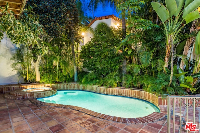 view of pool featuring a patio and an in ground hot tub