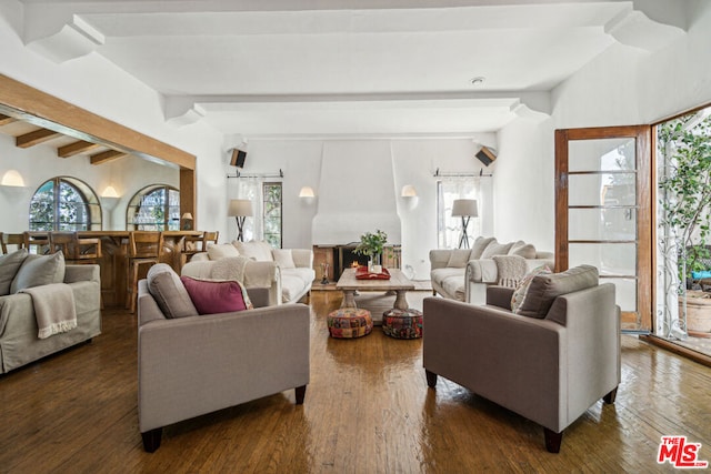 living room featuring beam ceiling and dark hardwood / wood-style floors