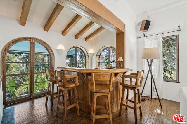 bar featuring lofted ceiling with beams and dark hardwood / wood-style flooring