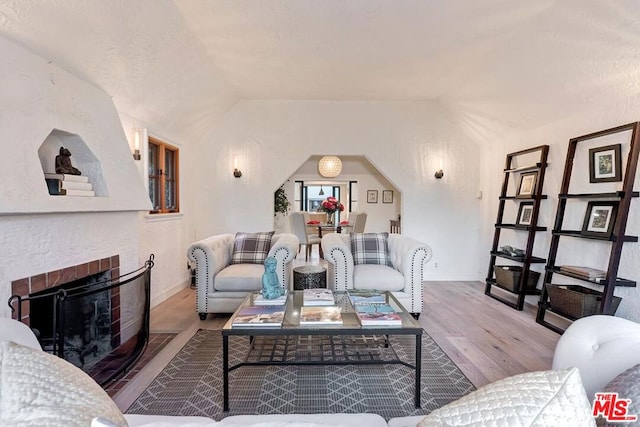 living room with vaulted ceiling and light wood-type flooring