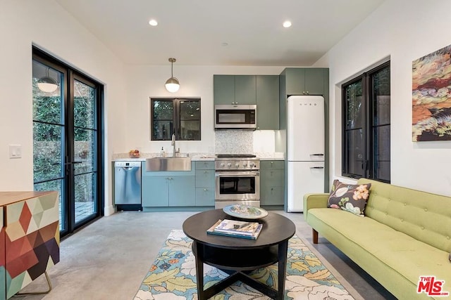 kitchen featuring tasteful backsplash, sink, hanging light fixtures, stainless steel appliances, and french doors