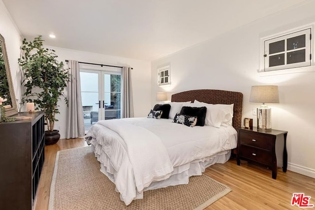 bedroom with french doors, access to exterior, and light hardwood / wood-style floors