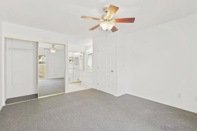 unfurnished bedroom featuring ceiling fan, a closet, connected bathroom, and carpet