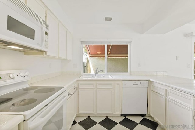 kitchen featuring white cabinetry, sink, and white appliances