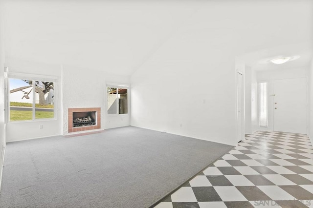 unfurnished living room with dark carpet and high vaulted ceiling