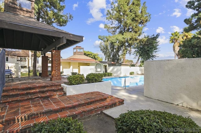 view of swimming pool featuring a gazebo and a patio area