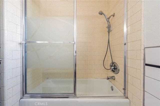 bathroom featuring combined bath / shower with glass door