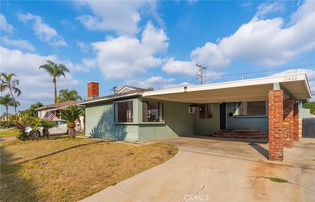 view of front of home with a carport and a wall unit AC