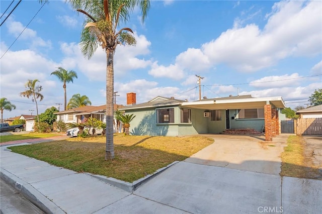 ranch-style home featuring a front yard and a carport