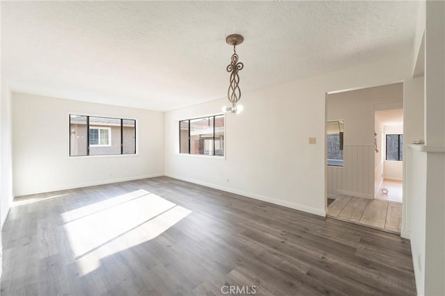 unfurnished room featuring dark hardwood / wood-style floors and a textured ceiling