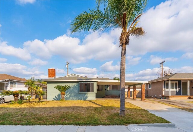 ranch-style house featuring a carport and a front lawn