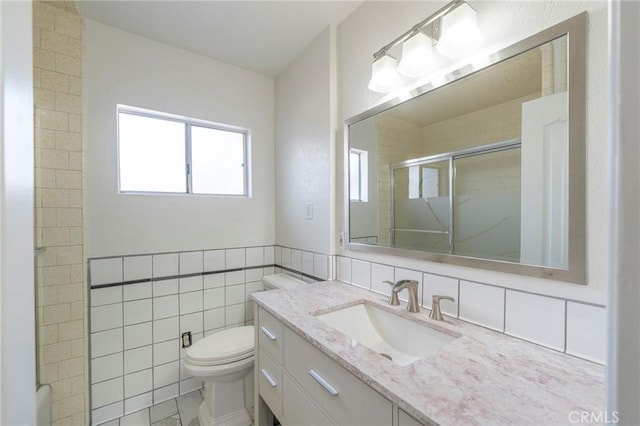 bathroom with tile walls, vanity, toilet, and walk in shower