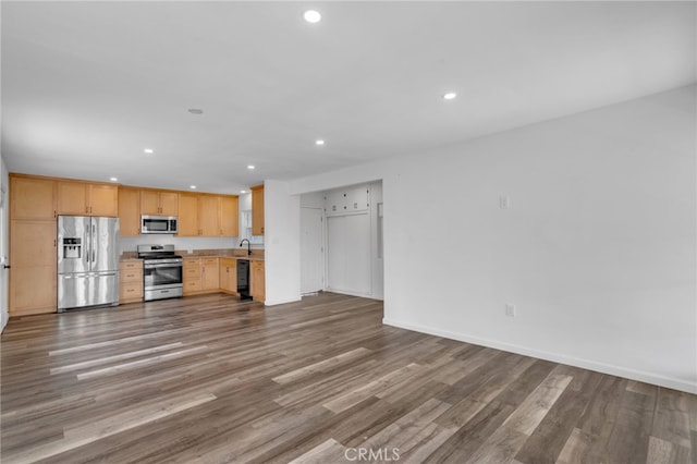 kitchen with wood-type flooring, appliances with stainless steel finishes, sink, and light brown cabinetry