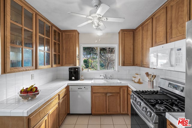 kitchen with white appliances, tile countertops, sink, and backsplash