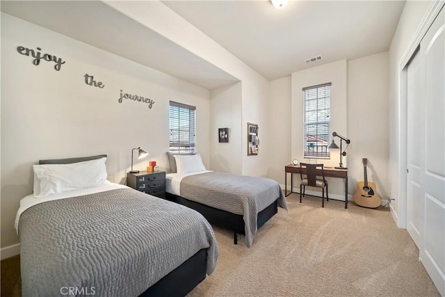 bedroom with light colored carpet, a closet, and multiple windows