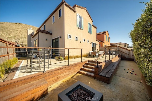 rear view of house with a fire pit and a patio