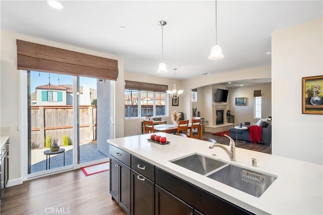 kitchen with sink, dark hardwood / wood-style floors, hanging light fixtures, and a chandelier