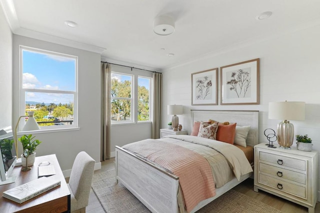 bedroom with ornamental molding and light hardwood / wood-style floors